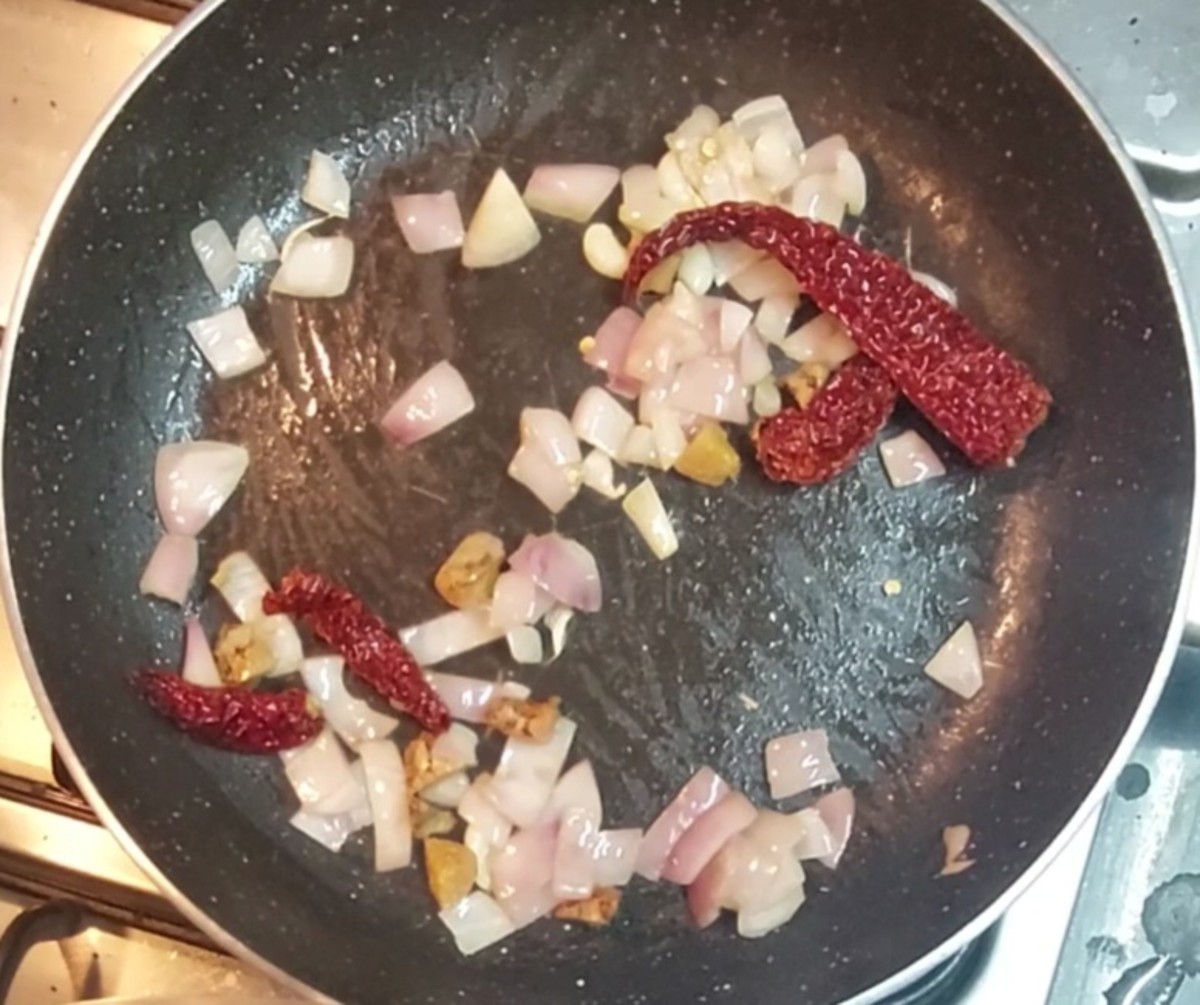 In a frying pan, heat 1 tablespoon oil. Add 5-6 garlic cloves, a 2-inch piece of chopped ginger and 3-4 red chilies. Fry for 1 minute. Add 1 chopped onion and fry till translucent.