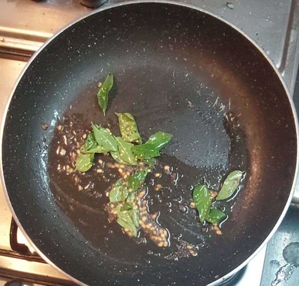 In a frying pan, heat 1 teaspoon oil and splutter 1/2 teaspoon mustard seeds. Add 1/2 tespoon urad dal and saute. Add a sprig of curry leaves and 1/4 teaspoon hing. Mix and switch off the flame.