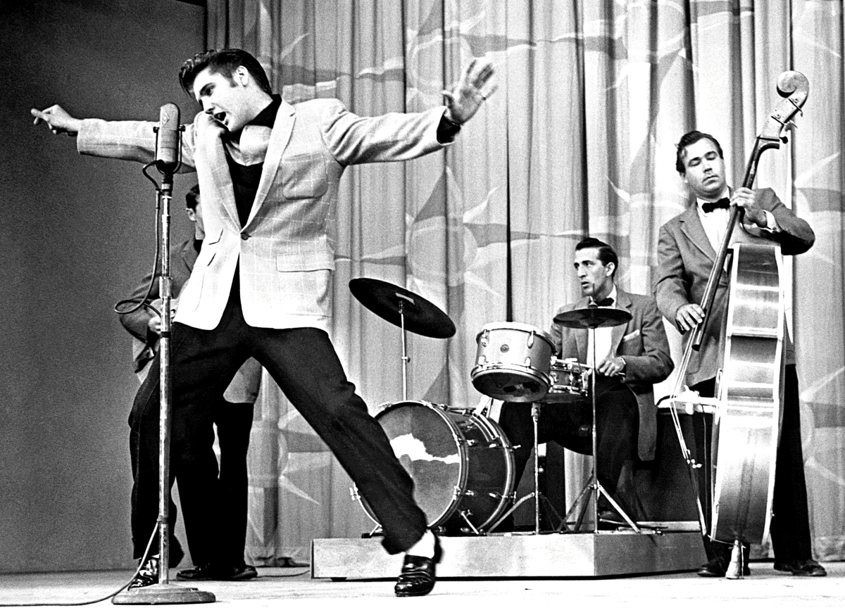 Elvis in 1955 with (L-R) Scotty Moore (obscured), DJ Fontana & Bill Black.