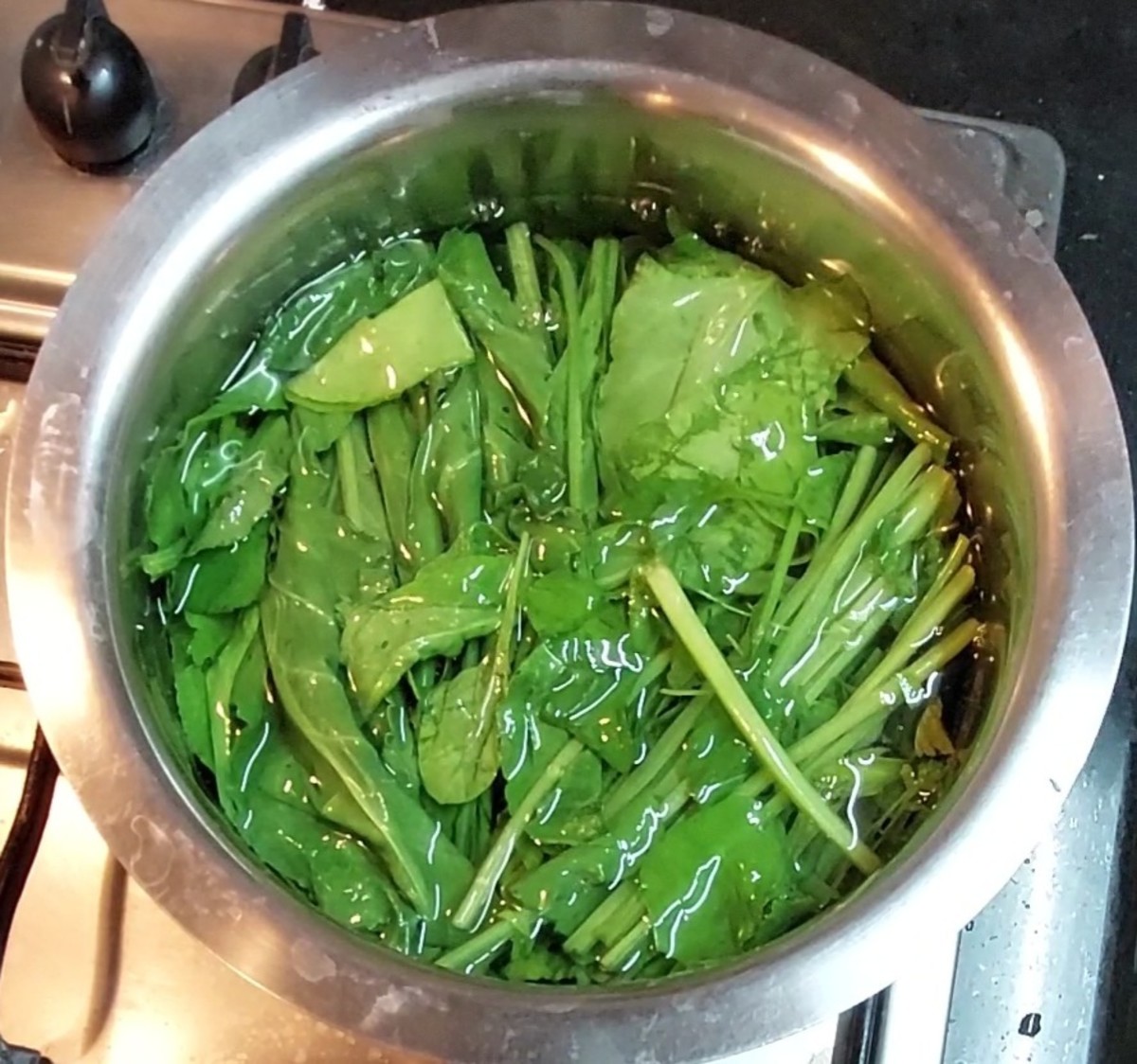 In a vessel, boil 4 cups of water. Add 2 cups of tender palak leaves and stems.