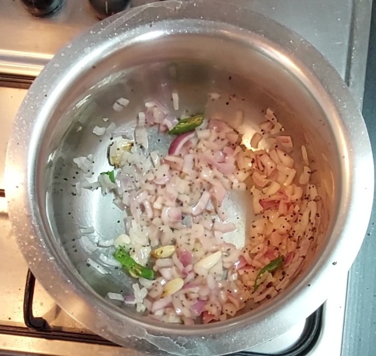 Add 1 cup chopped onion and 1-2 green chilies. Fry till onion turns translucent.