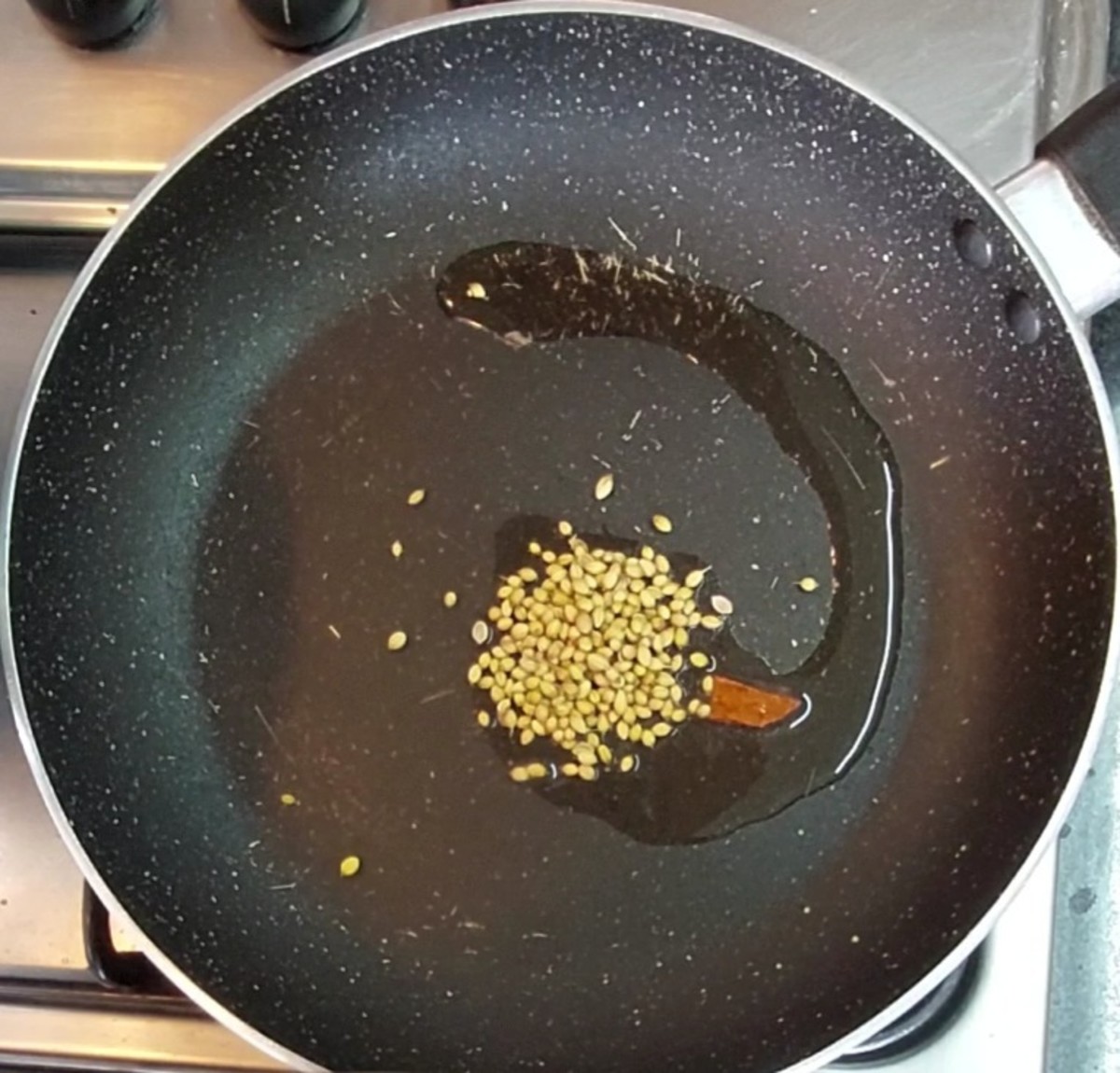 In a frying pan, heat 1 teaspoon oil. Add 1 inch cinnamon and 1 teaspoon coriander seeds.