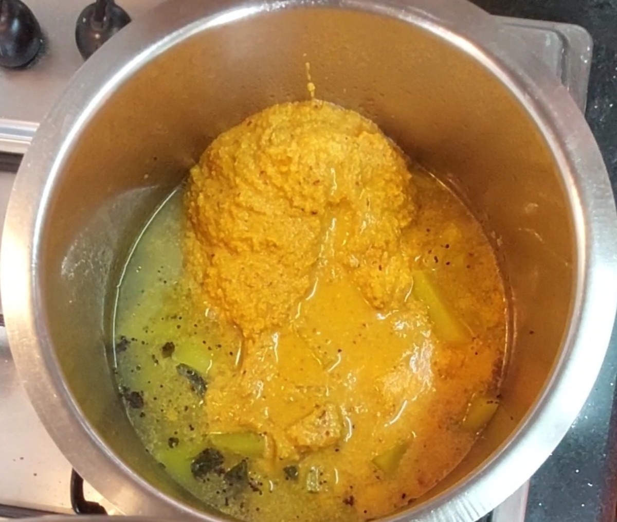 After the pumpkin is well-cooked, add the sambar and 1/2 cup water. Mix well.