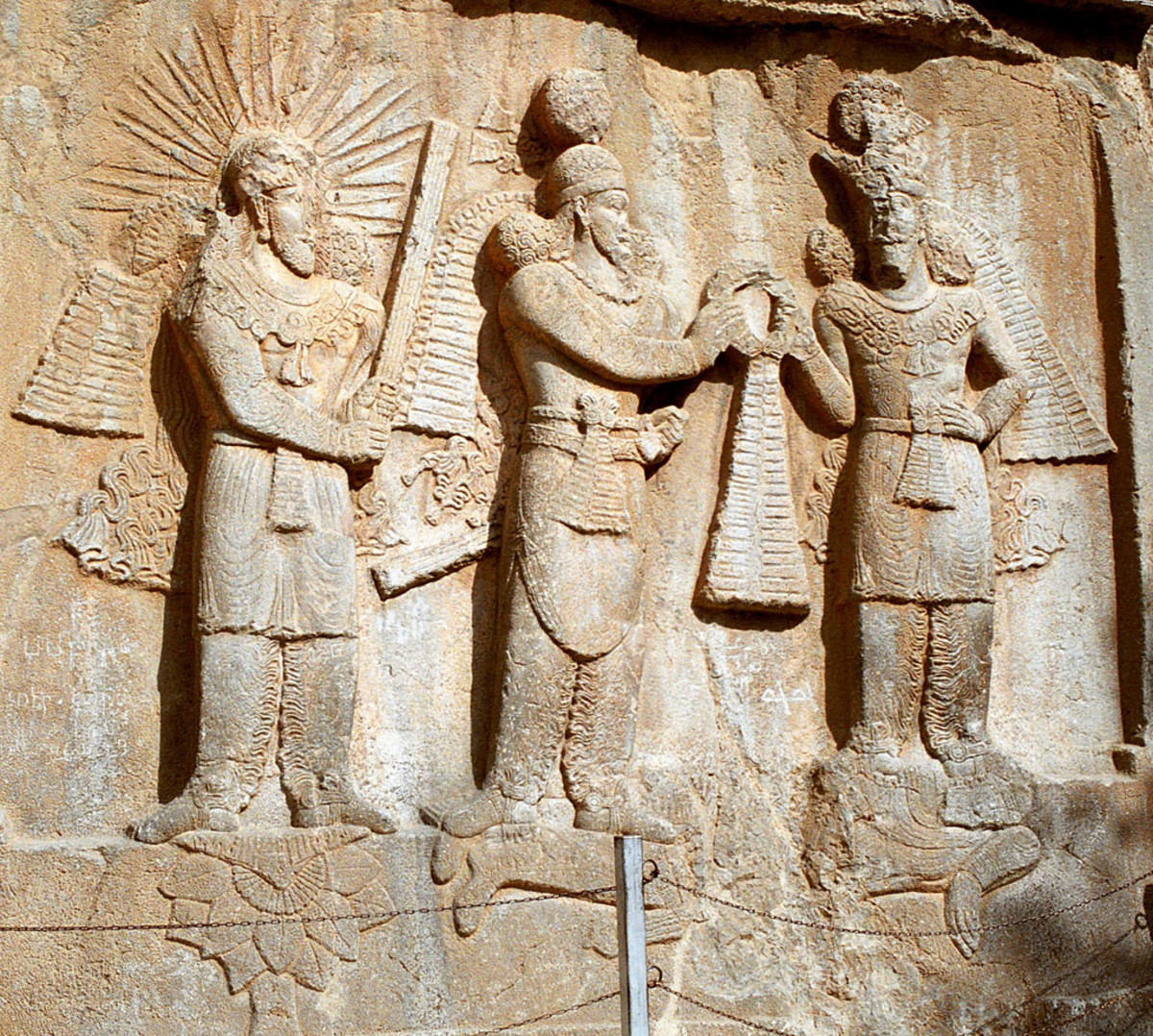 Mithra consecrating the investiture of Sassanid emperor Ardashir II. The god is standing at the leftmost.