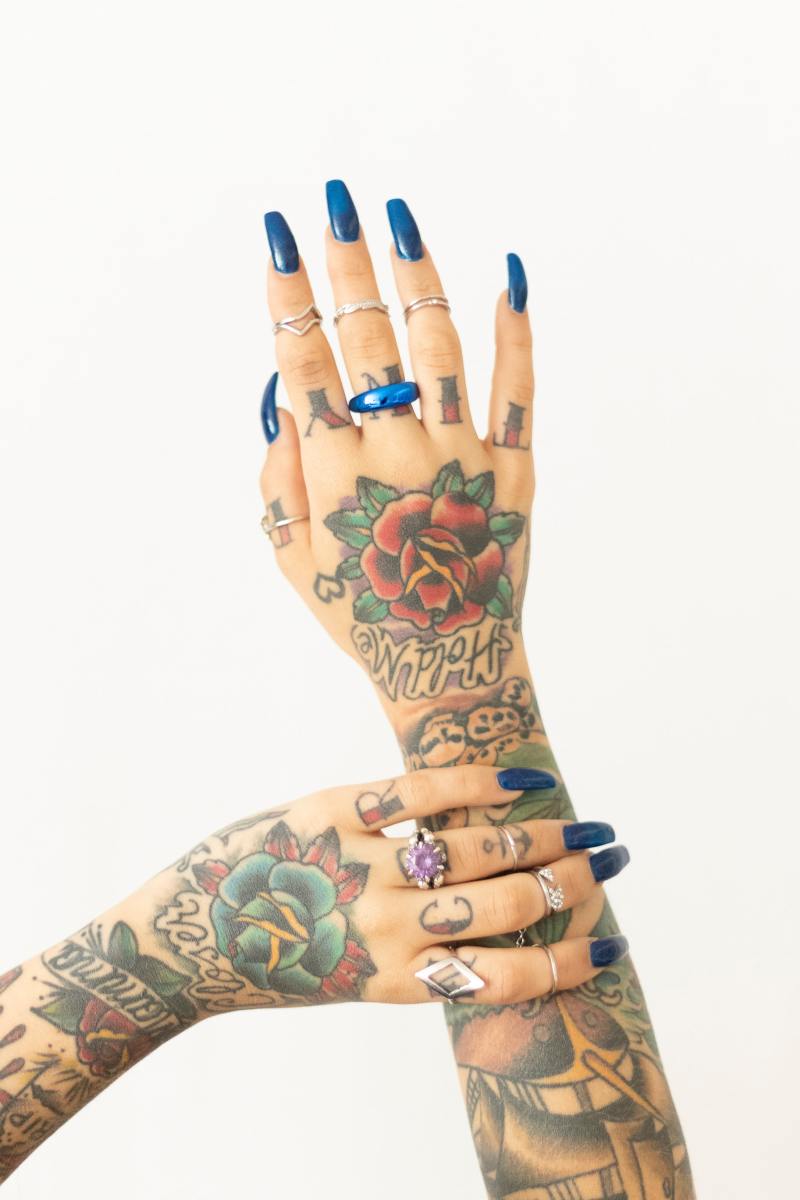 Body art on arms, hands, fingers, and fingernails. 