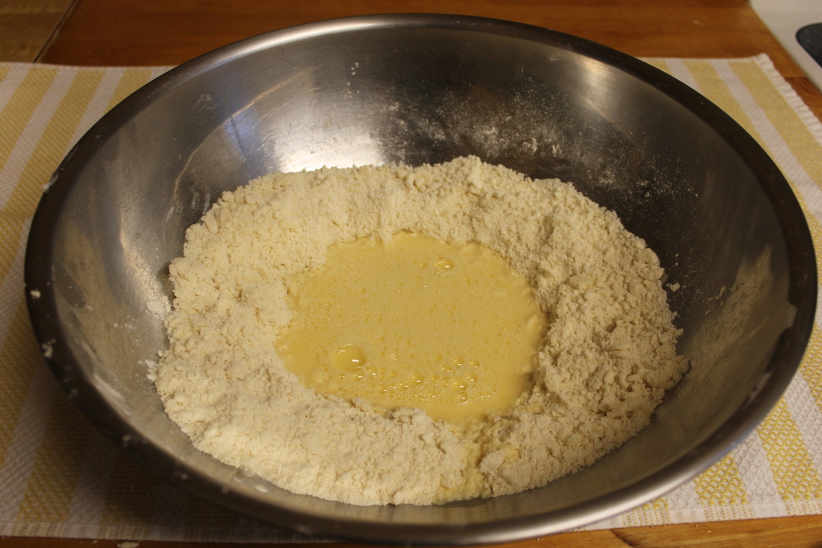 Make a hole in the middle of the flour mix and pour the egg mixture into it. Combine the ingredients together with your hands until the dough begins to form.