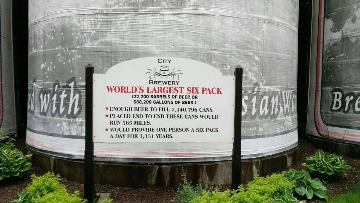 Sign giving details of the massive beer cans. 