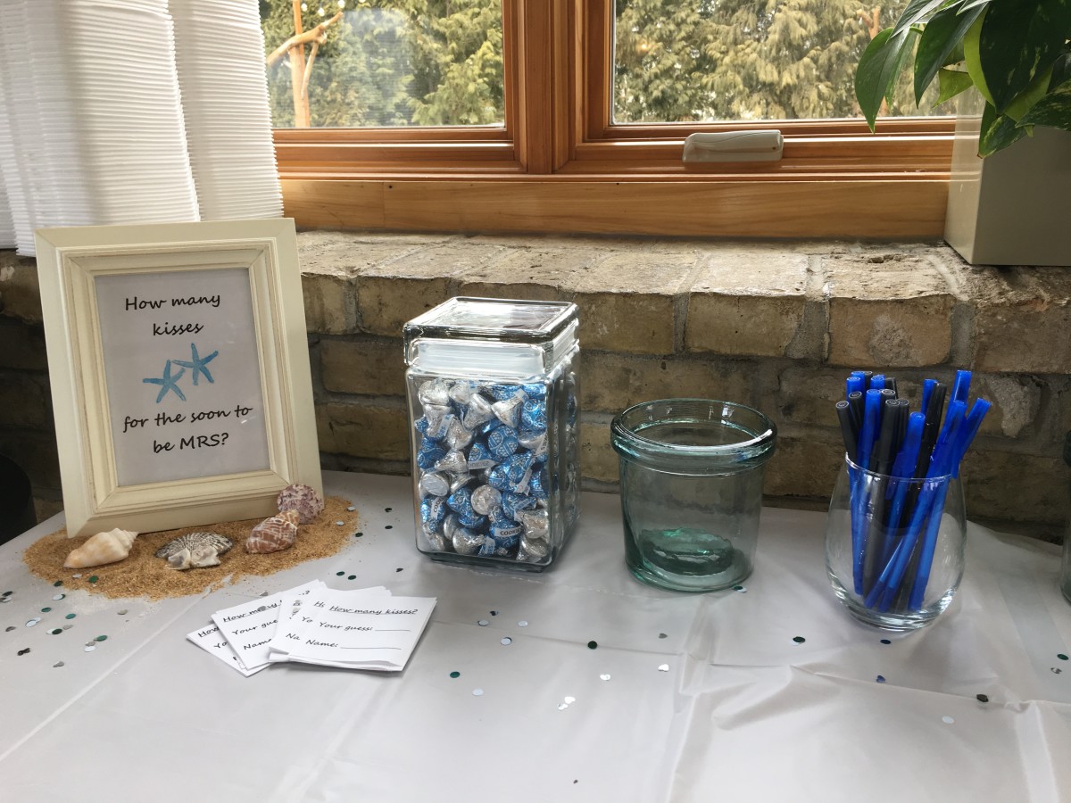 Make sure you count the kisses! Kisses come in many colors so it's easy to carry on the color scheme. Have a jar for the guests to place their guesses and plenty of pens! Notice the framed "name of the game" sitting on sand and shells