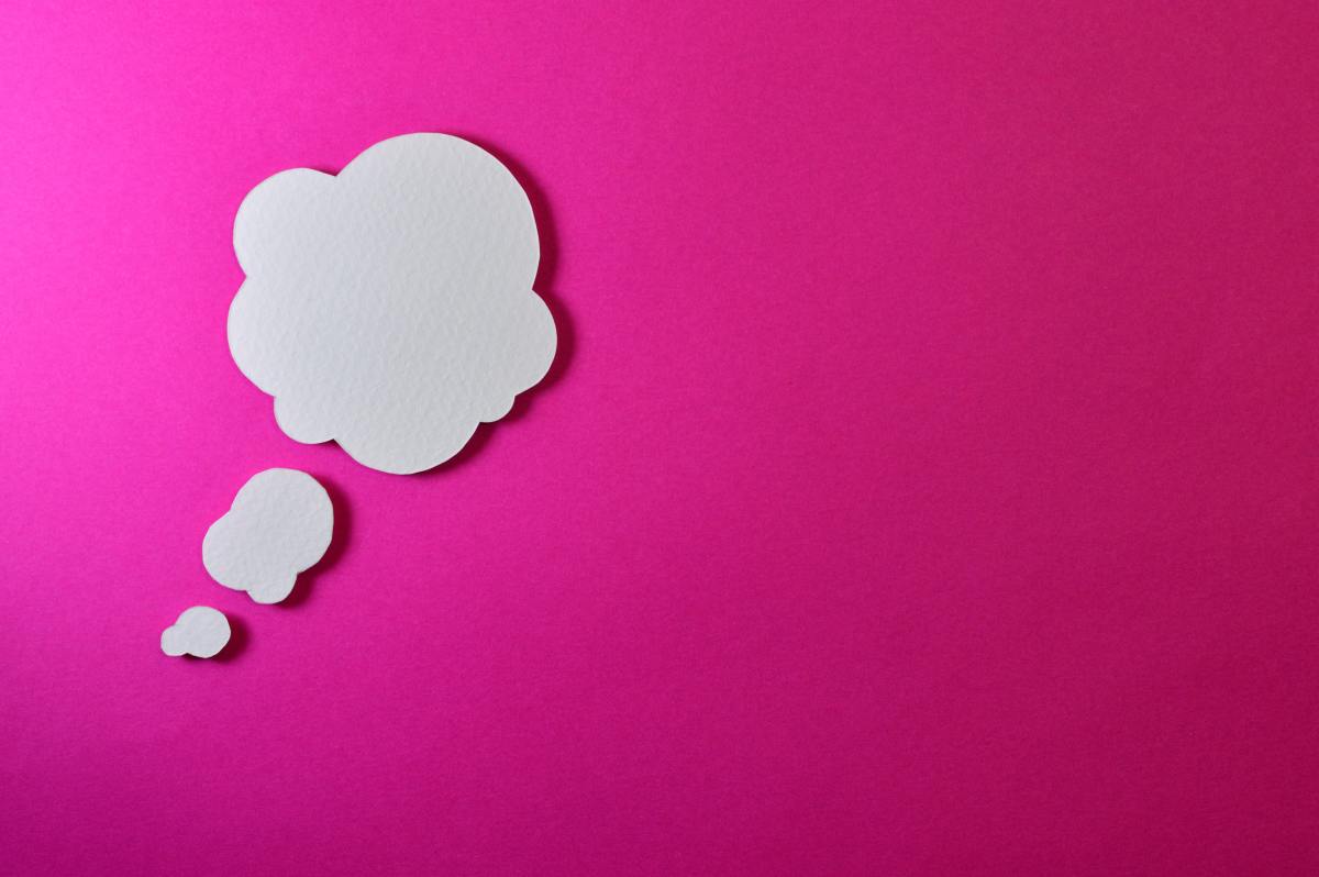 A white thinking cloud on pink background 