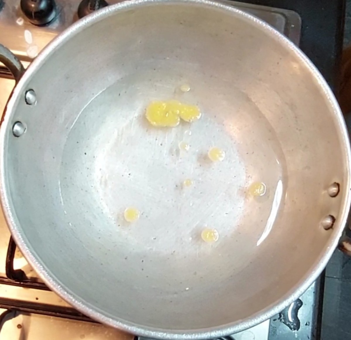 In a vessel or pan, add 2 cups of water, salt and 1 teaspoon ghee. Close the lid and let it come to a boil.