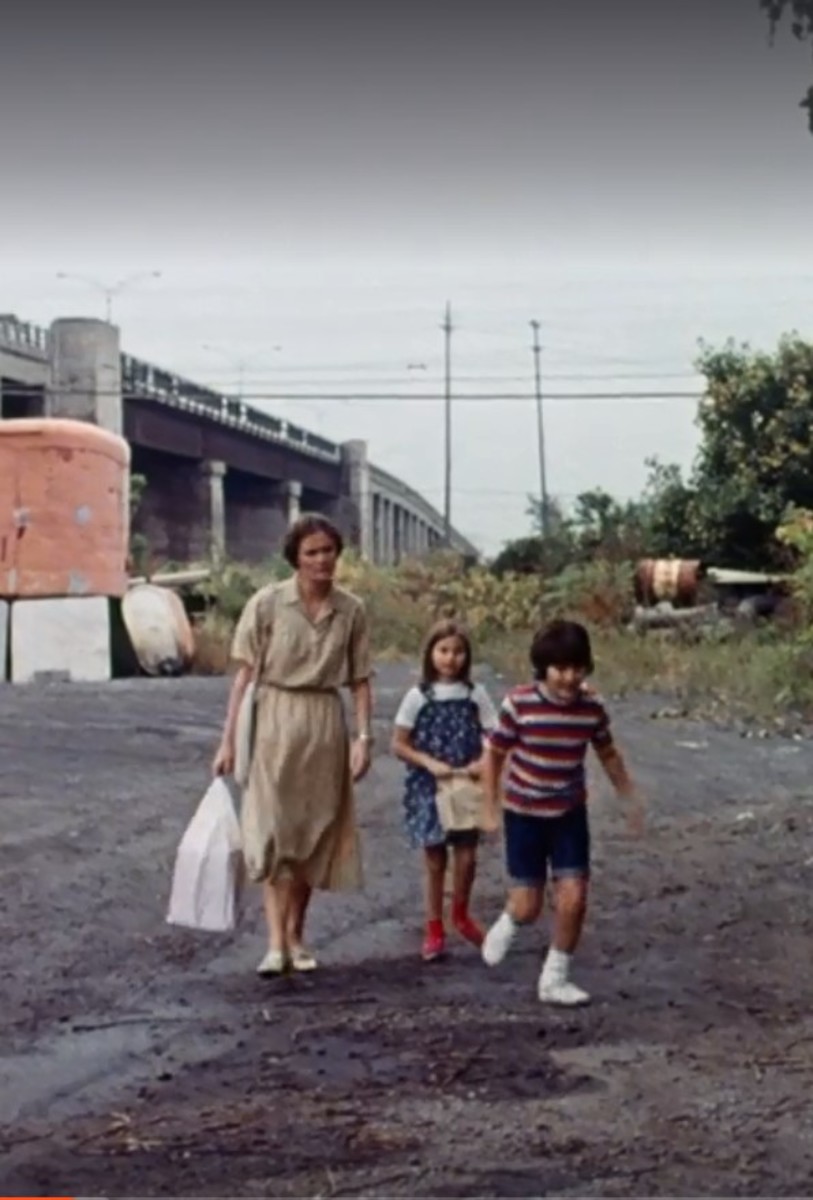 Mrs. Watts (Bronwen Mantel) and her children Debbie (Janice Chaikelson) and Gerald (Steven Chaikelson) head home after shopping.