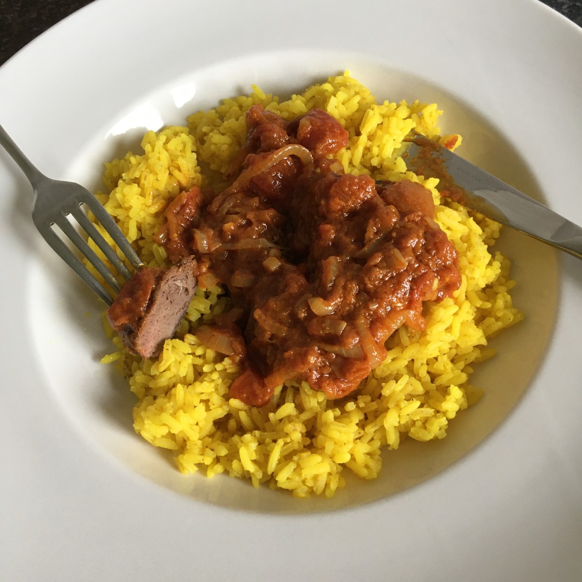 Pigeon breasts with simple Madras curry sauce is served on a bed of turmeric and garlic rice