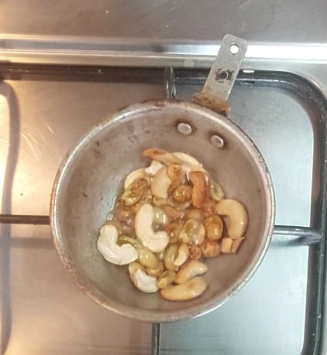 In a frying pan, heat ghee. Add cashews and fry till light golden brown. Add raisins and fry till fluffy. Switch off the flame.