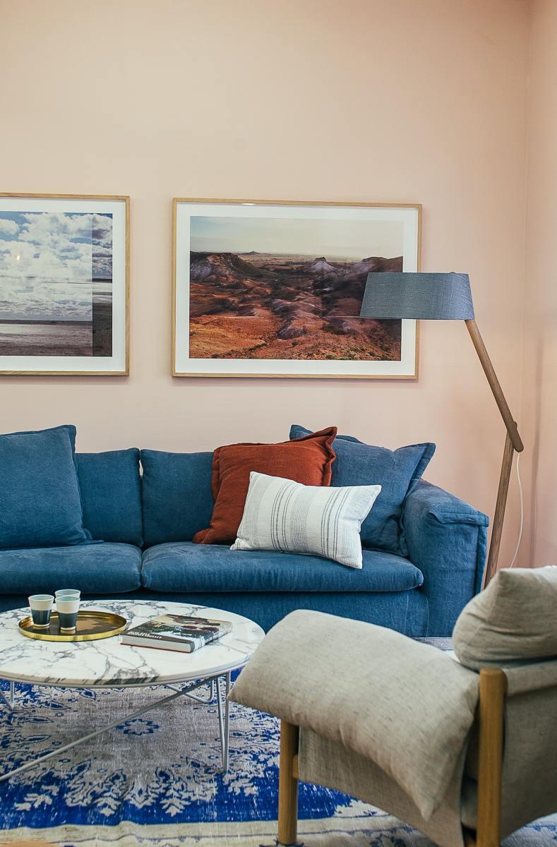 You don't have to have a cabin to get the right vibe for the Ox. A living room with a blue couch and rug with landscape portraits will do the trick.