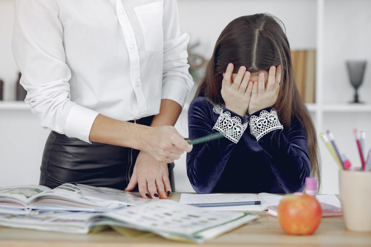 Little girl looks upset with both palms pressed to her face. We need to focus on teaching students how to deal with failure instead of constantly pushing for success.