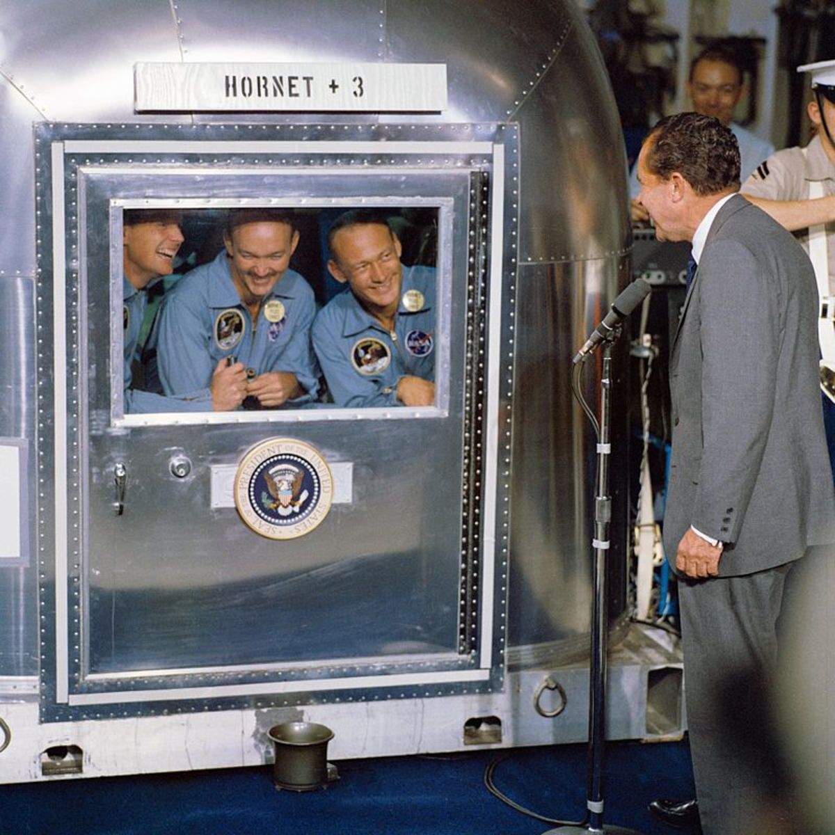 President Nixon greets the returning Apollo 11 astronauts in their quarantine trailer.