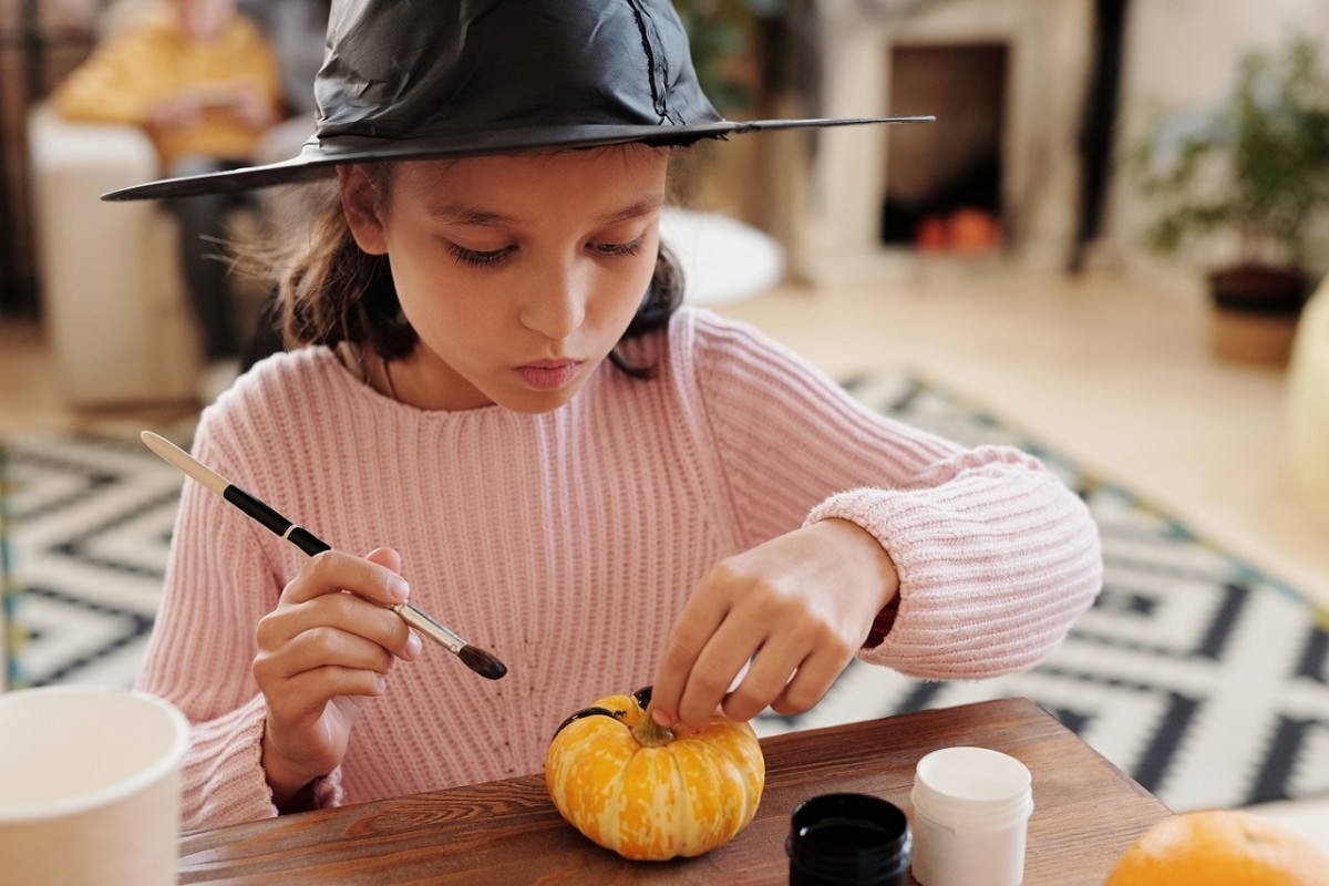 Get your kids involved with decorating pumpkins. Let them know that simple, homemade items are the best, including being comfortable at home in a sweater and your witch's hat.