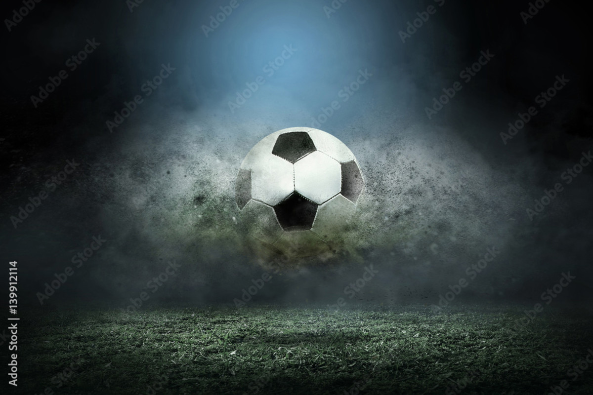 Soccer ball at the fore of a storm cloud moving across a soccer field.