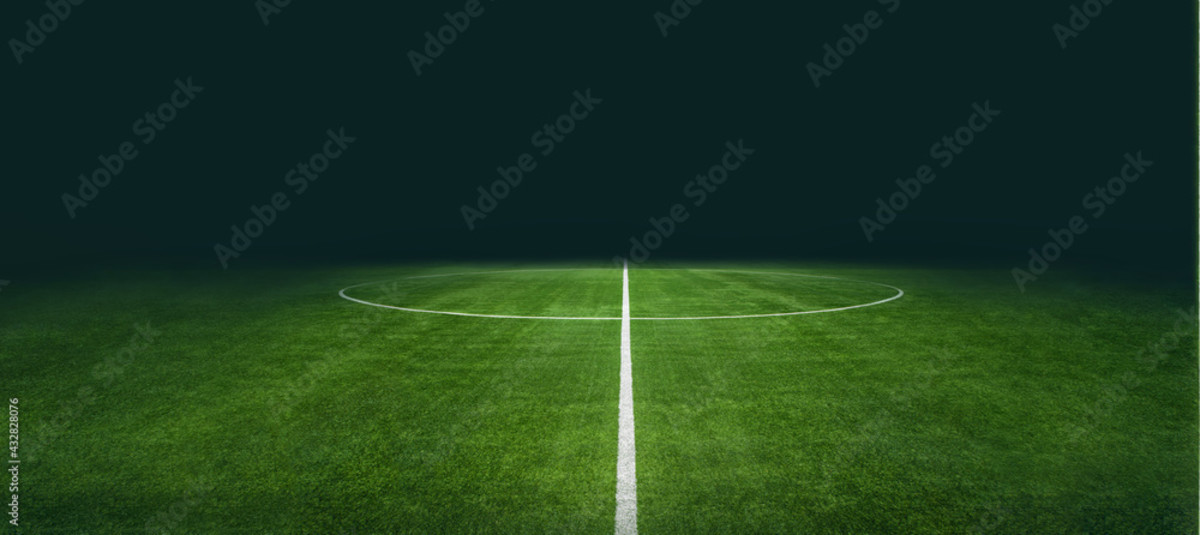 Image of empty soccer field sky is black in background.