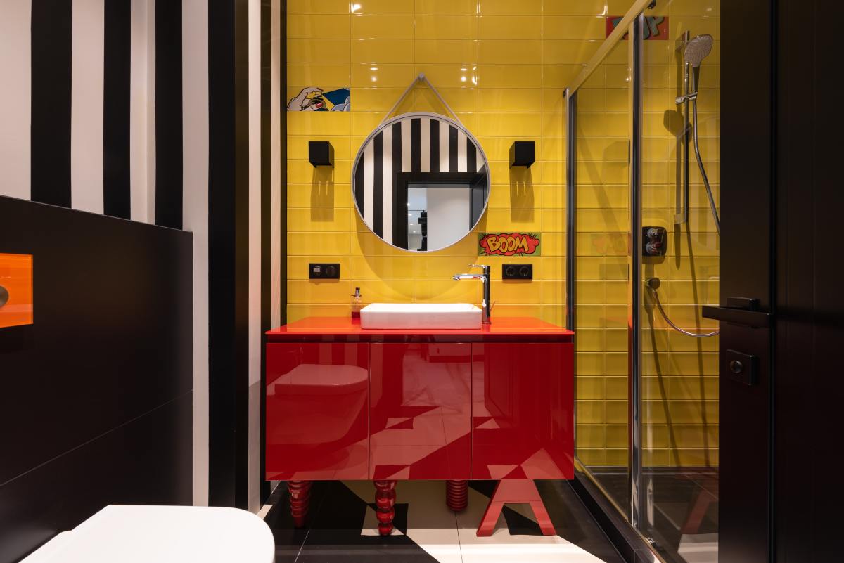 There is a lot going on in this bathroom, so you may want to tone it down for your own bathroom. It is distinctly snake-like though. There are white and black striped walls, yellow tiled walls, and a red vanity.