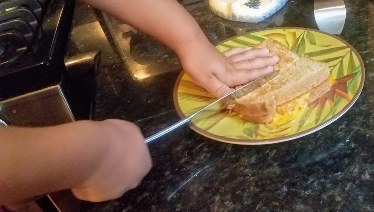 My son slicing the toasted grilled cheese he made.  