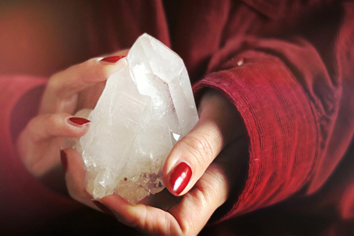 Close-up photo of person holding a natural crystal.