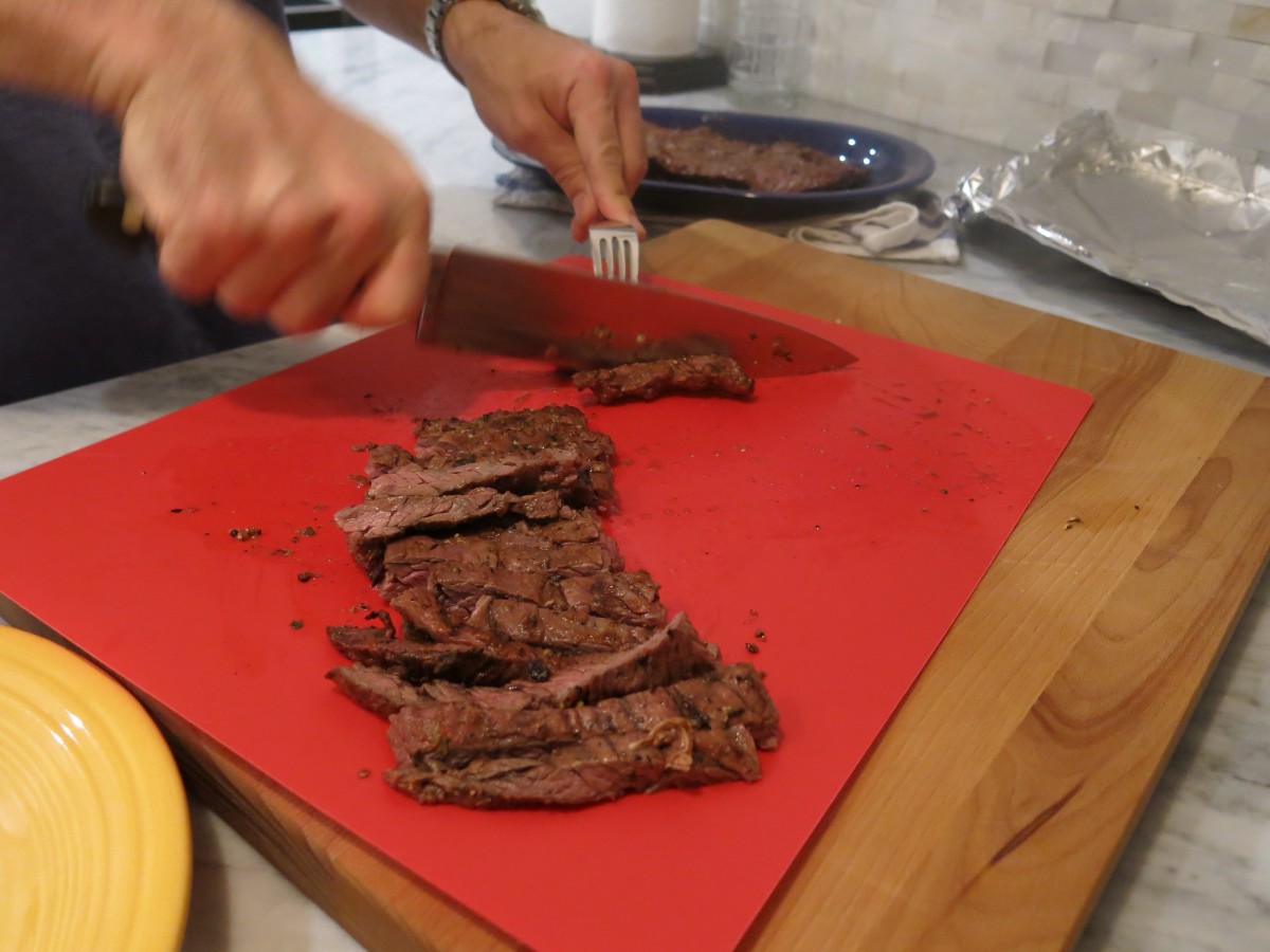 Our assistant chef is slicing grilled flank steak against the grain