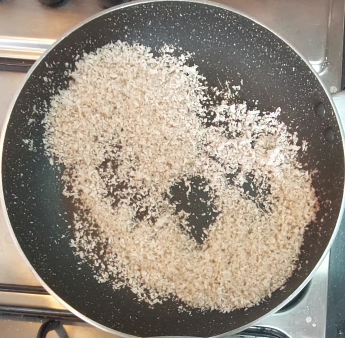 In the same pan, add 1/2 cup fresh grated coconut. Fry for 5 minutes or till the coconut dries. Transfer to a plate.