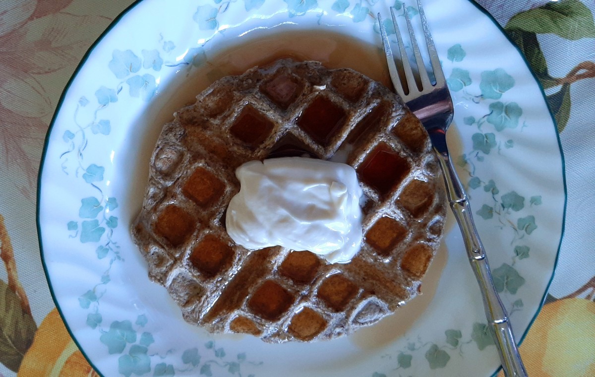 A delicious oat-chia seed waffle saturated in maple syrup and topped with a blip of coconut yogurt