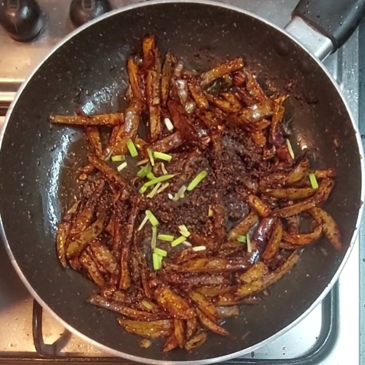 Mix the fried potatoes well with the sauces. Add fried sesame seeds, 1 tablespoon and chopped spring onion. Mix well and switch off the flame.