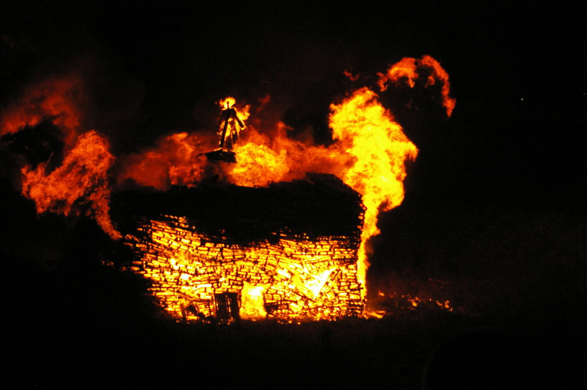 A great bonfire on Guy Fawkes Day with an effigy of the failed Catholic revolutionary  Fakes in flames above the blaze.