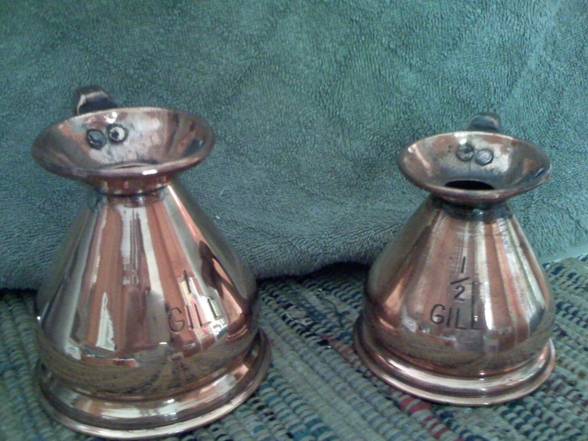 Two copper measuring jugs: 1 gill measure (left) and 1/2 gill measure (right).