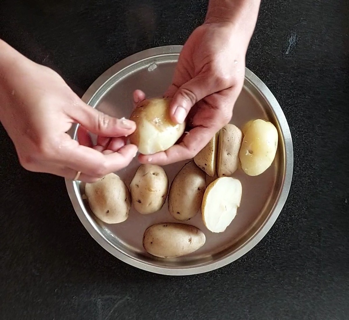 Once the pressure releases, open the cooker and transfer the cooked potatoes to a plate. Let them cool down. After cooling, peel off the skin.