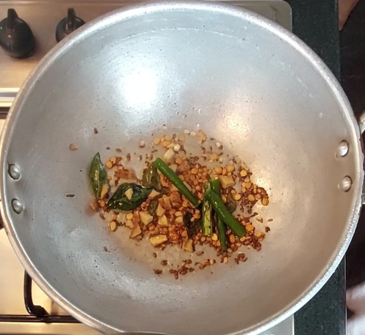 Saute for 1 minute or till lentils turn golden brown. Do not burn. Add 1 teaspoon chopped ginger and 1-2 green chilies. Saute for a few seconds.