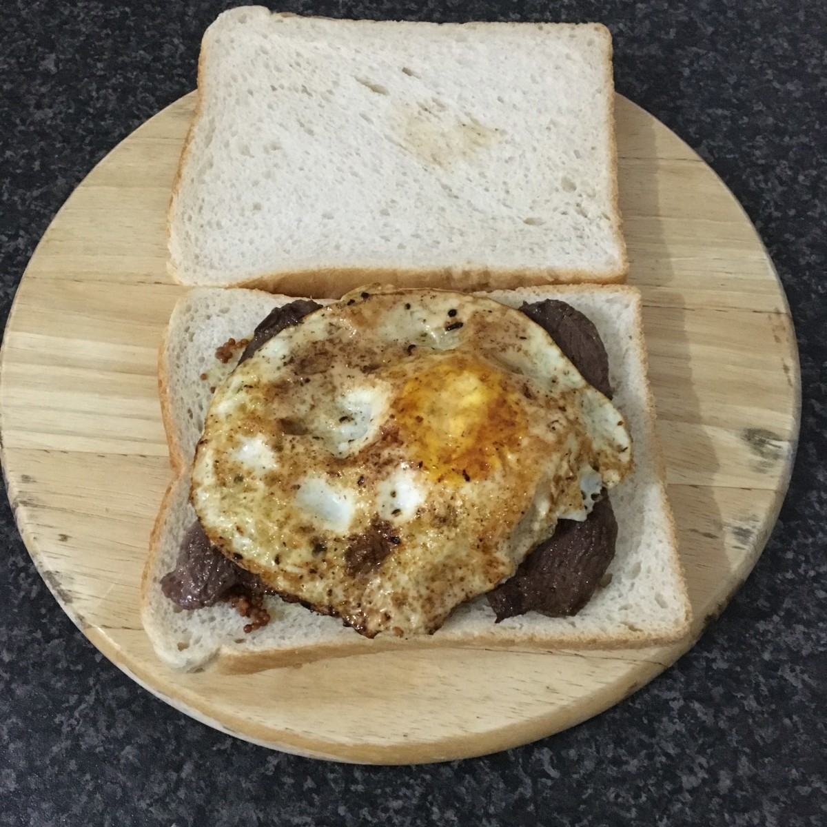 Fried egg on fried slices of wild goose breast sandwich