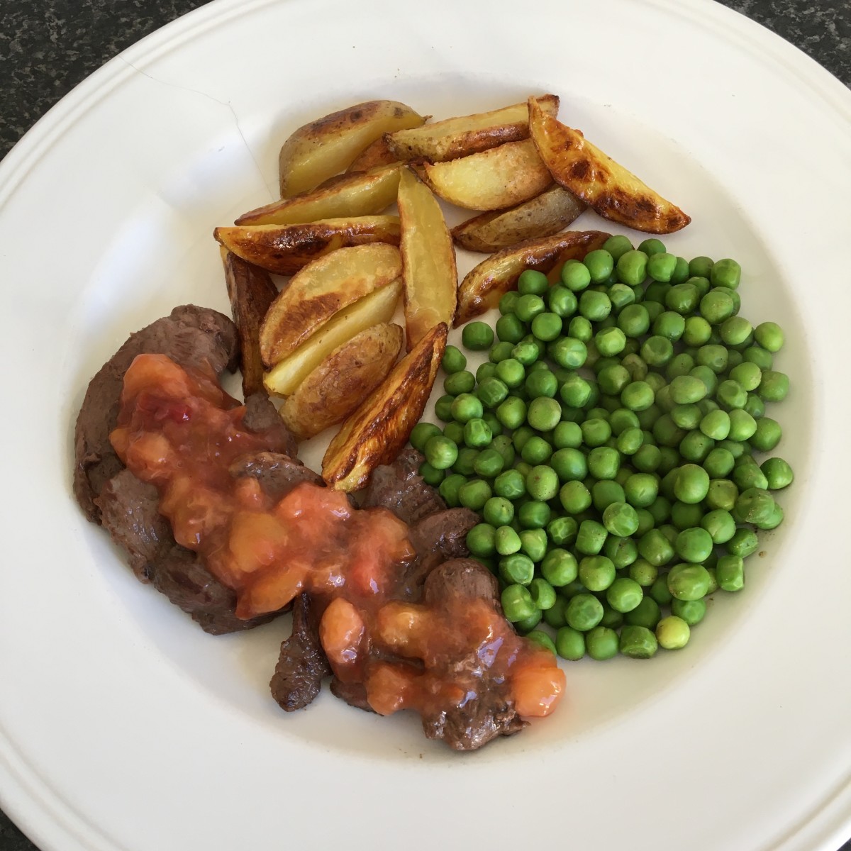 Goose breast with plum sauce, potato wedges and peas