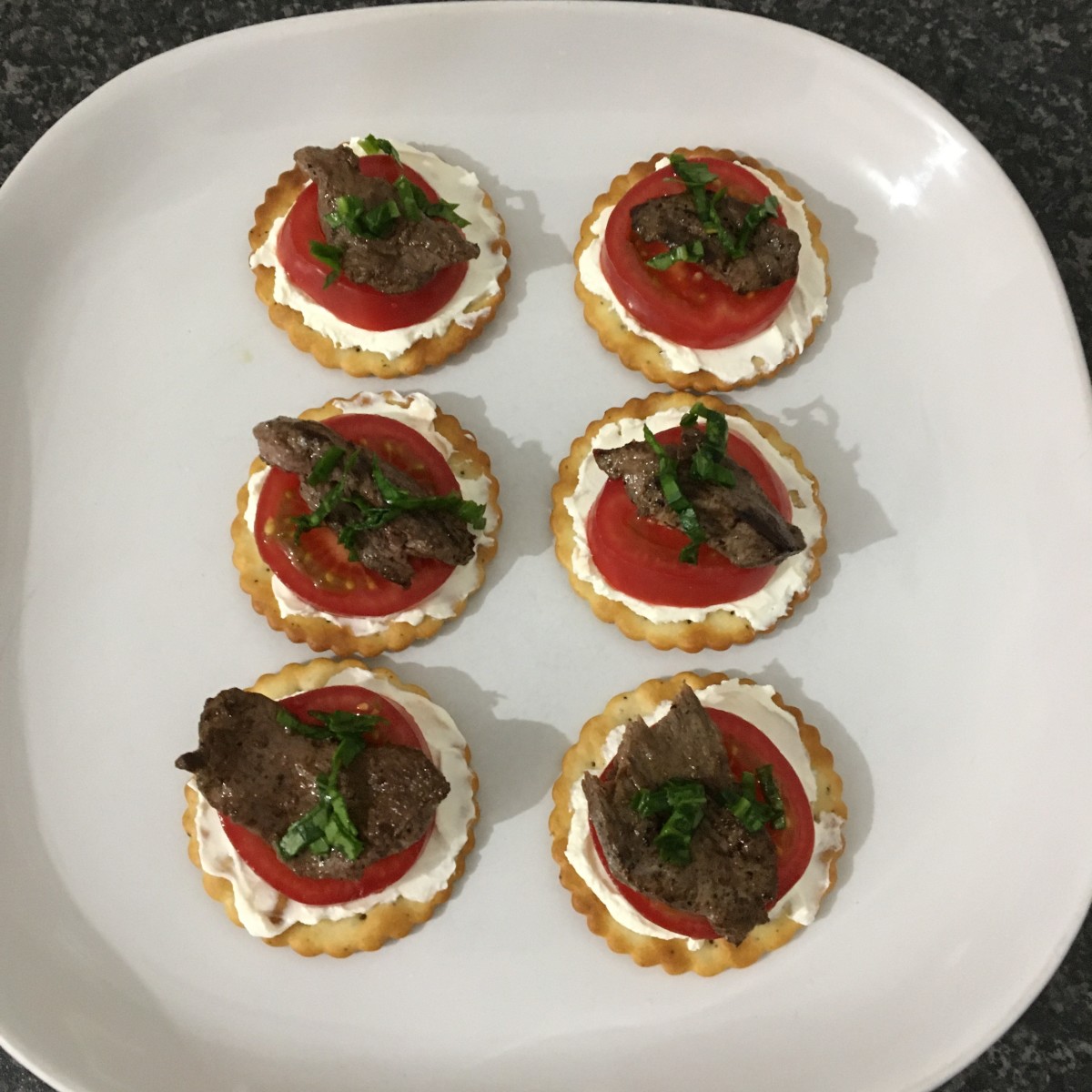 Goose breast, tomato and cream cheese on crackers hors d'oeuvres