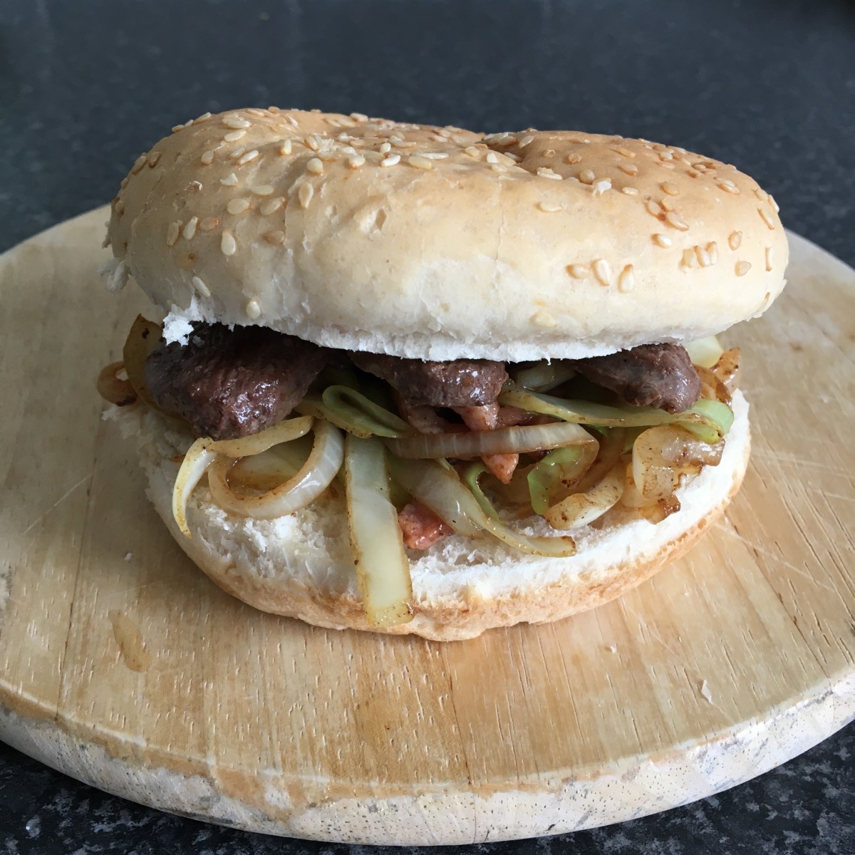 Wild goose on a bun with cabbage, bacon and onion