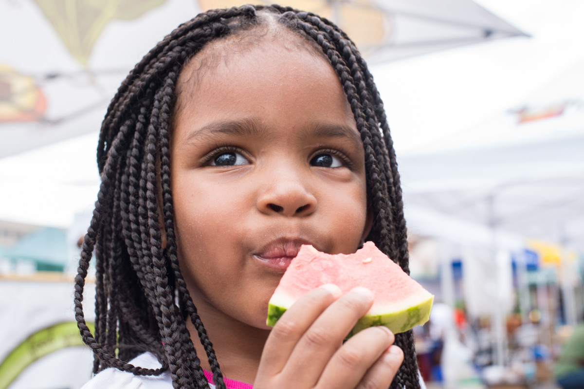A young girl eats a healthy slice of watermelon.