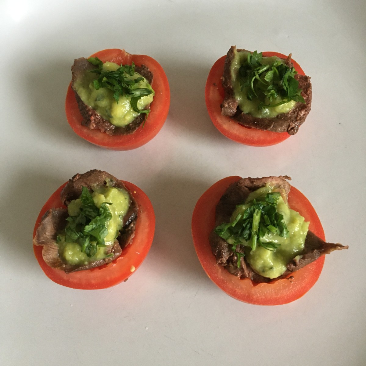 Tomato halves stuffed with chilli spiced pigeon and guacamole