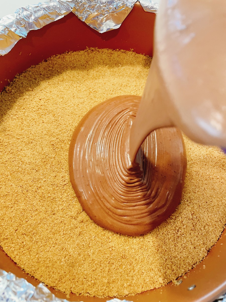 Pour the cheesecake mixture into the baked crust in the prepared pan. 