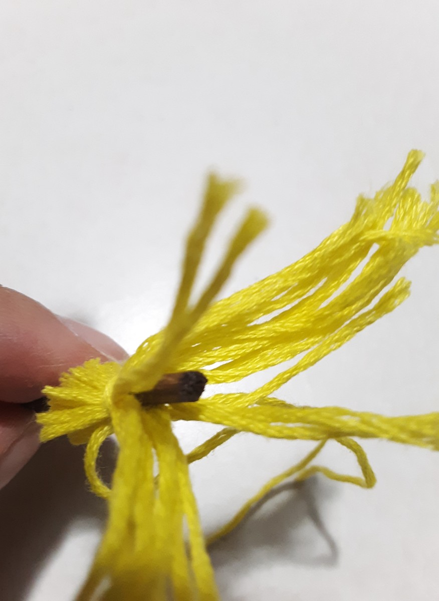 Lift bristles and add glue, then gently put bristles back down. Be careful not to let glue spill on all over yarn.