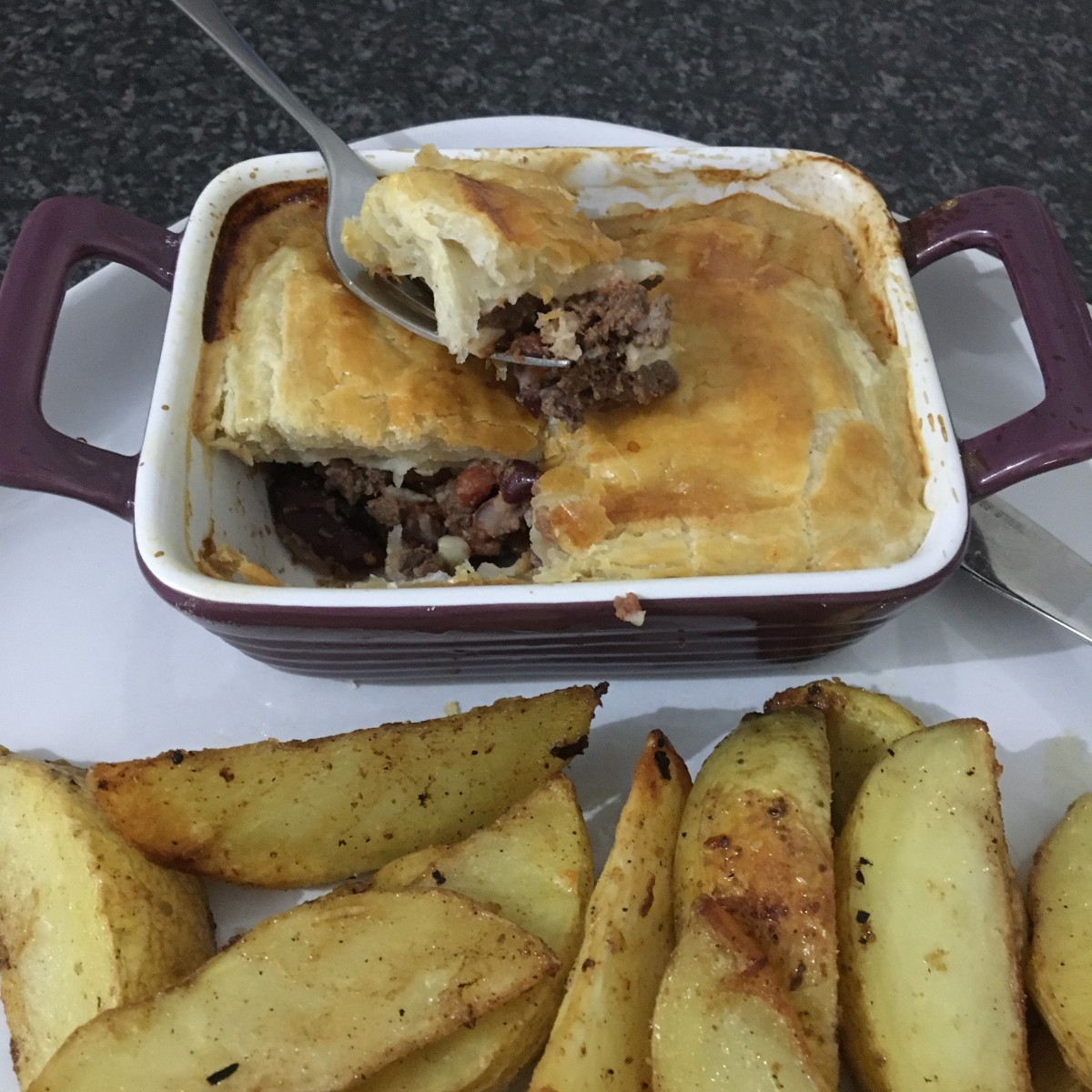 Simple pigeon chilli pot pie is served with spicy baked potato wedges