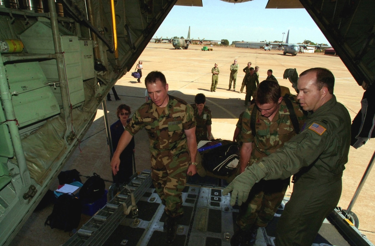 US Air Force (USAF) Captain (CAPT) Keith Reed, right, a Flight Nurse with the 185th Airlift Squadron, 137th Airlift Wing, Oklahoma Air National Guard directs other flight nurses and personnel.