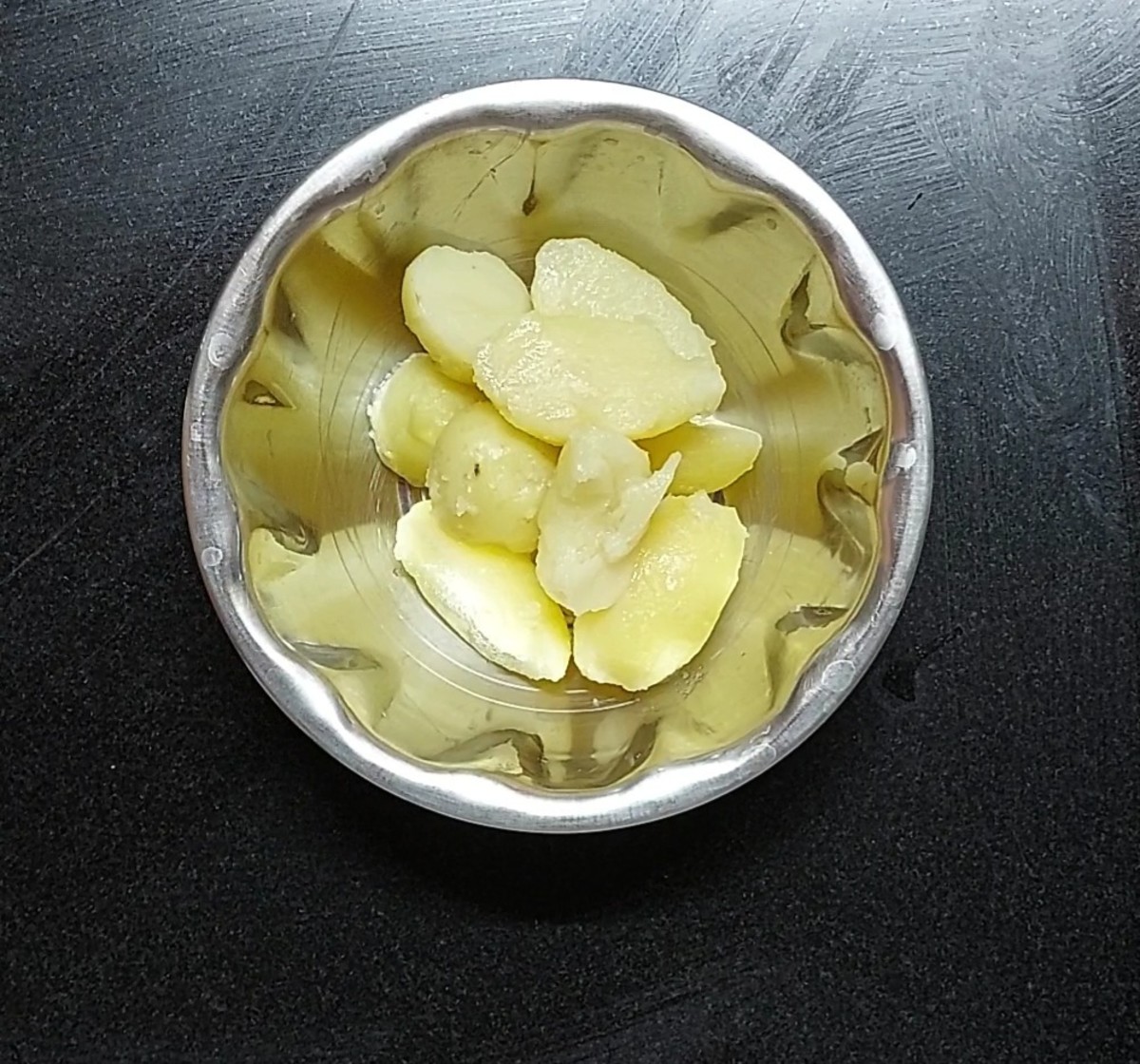 In a vessel, place 4-5 cooked and peeled potatoes.