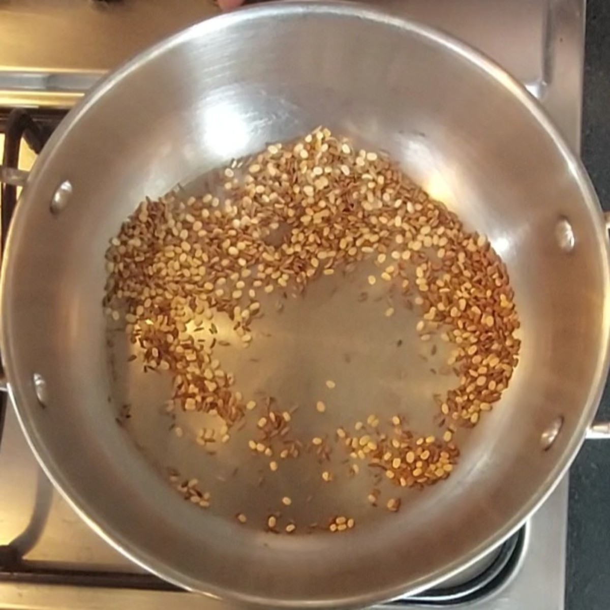 Fry over low flame till urad dal turns golden brown and aromatic. Transfer to a bowl.