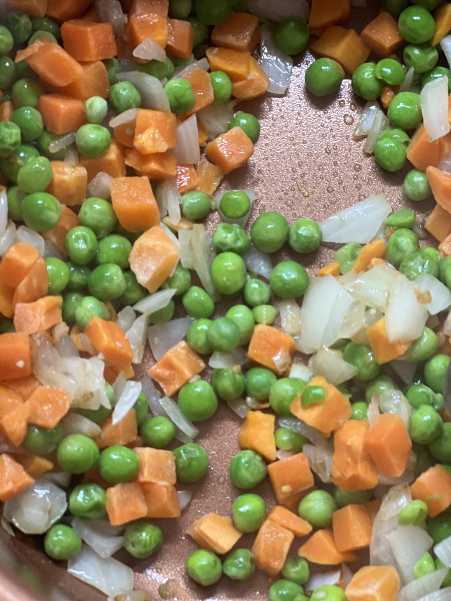 Add the carrots and peas to the sauteed onions and garlic.