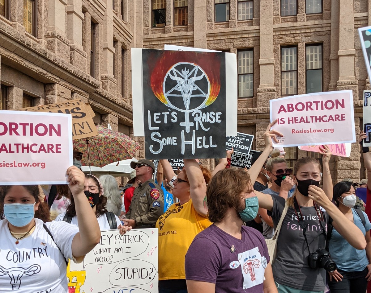 Satanic sign from a rally against Texas SB 8 reading "let's raise some hell"
