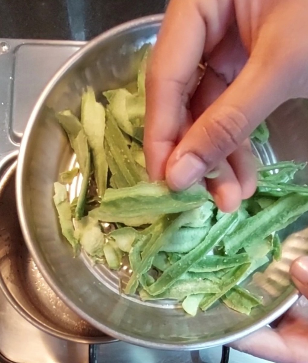 In the same frying pan, heat 1 teaspoon oil and add 1/2 cup ridge gourd peels. Saute for 1 minute. 