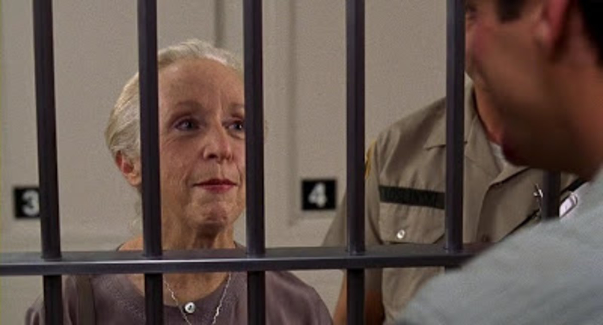 Greta (Anne Haney) visits her boss in prison. 